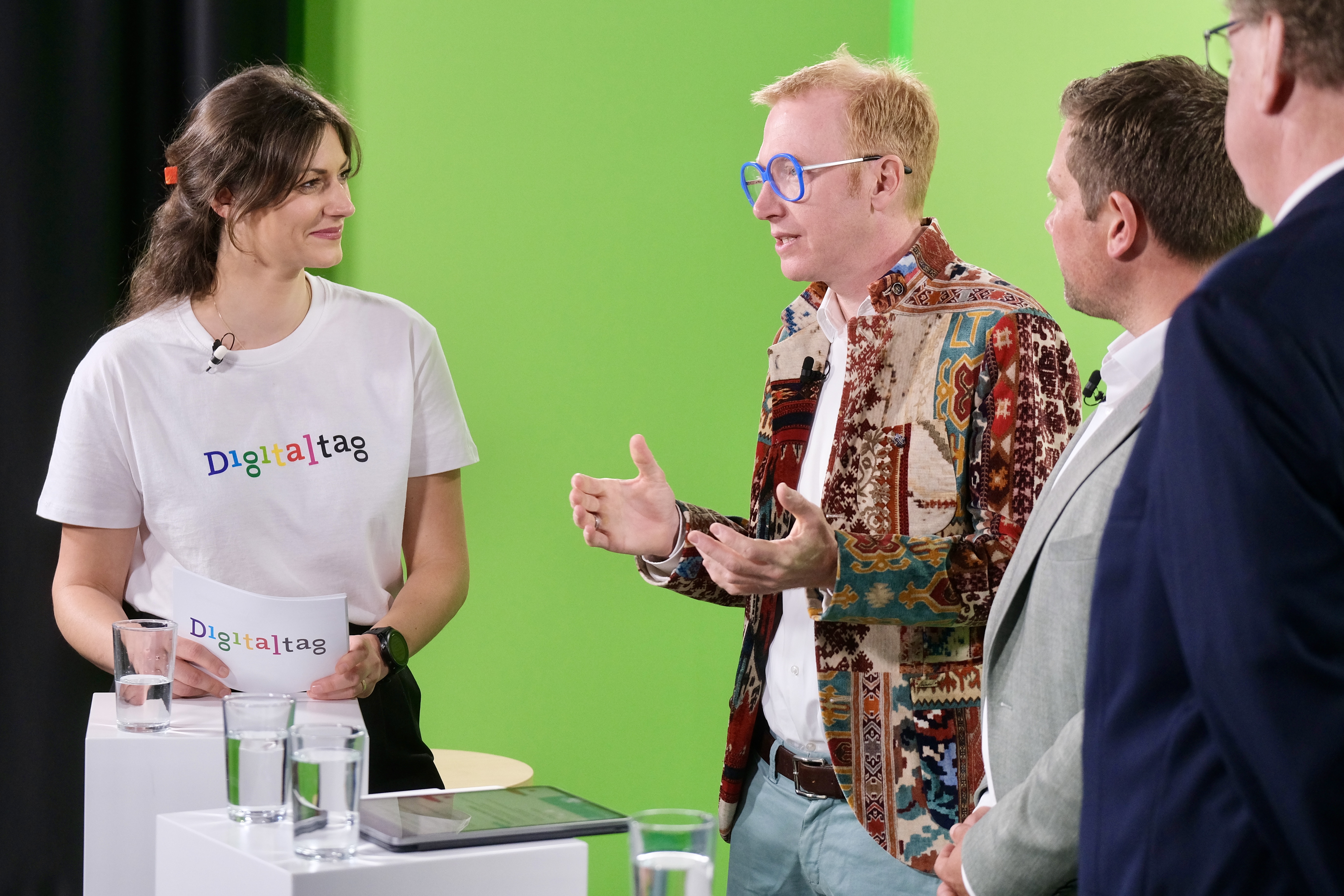 Vier Personen vor einem Greenscreen.